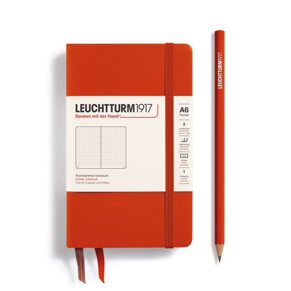 A small, fox red notebook with an elastic.